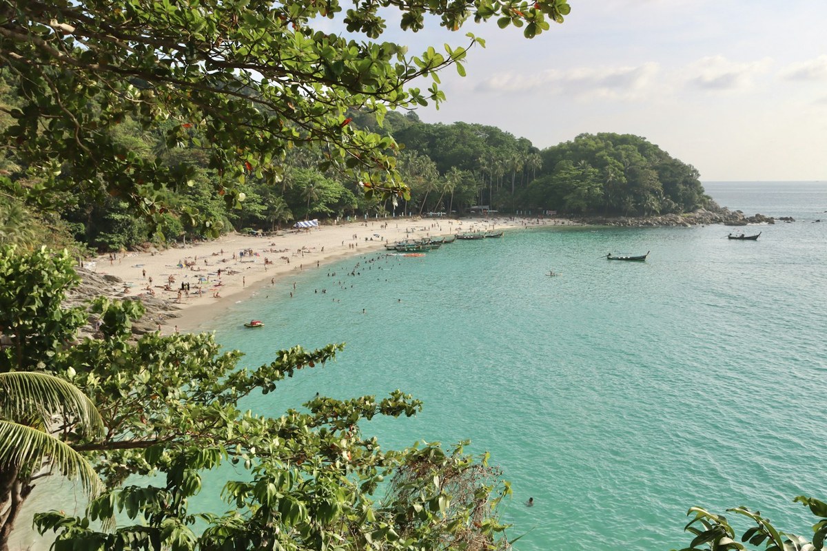 a beach with many boats and people on it